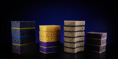 Several towers made of sponge on a beautiful blue background. Household sponge. photo