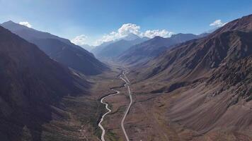 View a serene mountain valley from above with a river running through the scenery video