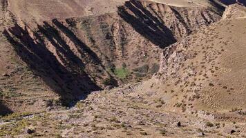 Aerial view of rocky cliffs, a valley with sparse vegetation in a serene, untouched wilderness video