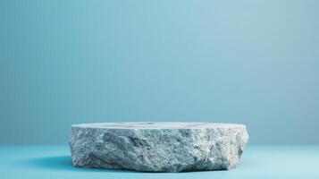 A rough stone pedestal stands alone in a minimalist studio with soft blue lighting, creating a serene and modern ambiance. photo