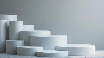 Several white cylindrical podiums of varying heights are neatly arranged in a stepped pattern against a minimalist gray background in a modern studio setting. photo