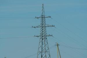 High voltage towers with sky background. Power line support with wires for electricity transmission. High voltage grid tower with wire cable at distribution station. Energy industry, energy saving photo