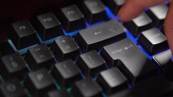Finger pressing Enter key on backlit keyboard video