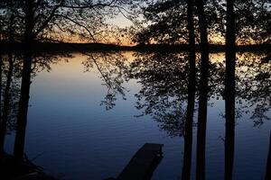 Sunset over lake with trees at shore photo