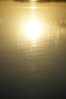 Sun reflecting in lake at sunset - close-up photo