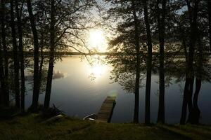 Sunset over lake with trees at shore photo