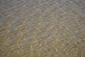 Clear and calm water surface at shore photo