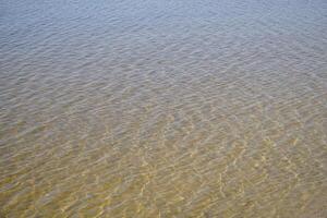Clear and calm water surface at shore photo