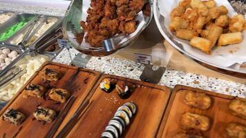 Asia buffet On the plate Asian food sushi in batter chicken fish in the buffet pick up different food with chopsticks eat choose video