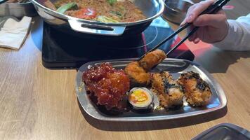 Asia buffet On the plate Asian food sushi in batter chicken fish in the buffet pick up different food with chopsticks eat choose video