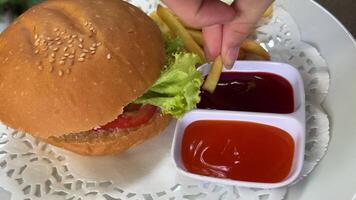 Cheeseburger topped with fresh lettuce and tomato on a sesame seed bun, ready to be enjoyed. video