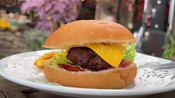 Cheeseburger topped with fresh lettuce and tomato on a sesame seed bun, ready to be enjoyed. video