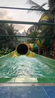 aqua parque, lista baixa a deslizar do água cano. piscina do a água parque frente visualizar. final de semana Como uma família com crianças em água atrações video