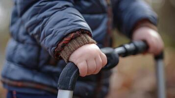 A child with cerebral palsy using a walking stick for assistance with walking photo