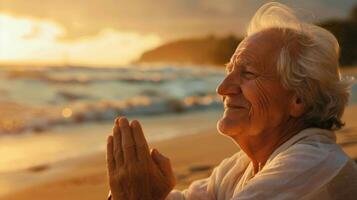 An elderly person smiling while practicing meditation at a peaceful beach photo
