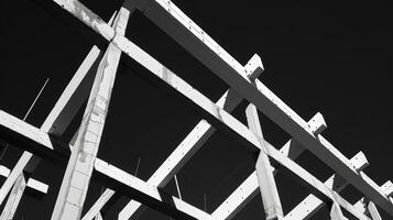 The beams of the unfinished structure are outlined in white against the black sky creating a striking contrast photo