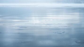 The smooth and mirrorlike surface of a frozen lake enhanced by the faint hint of shimmering colors photo