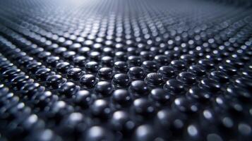 A closeup view of a conveyor belt comprised of small tightly spaced bumps that resemble a field of goosebumps on the rubber surface photo