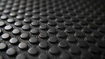 A macro shot showcasing the intricate details of a rubber mats beehivelike pattern with small circles and hexagons in varying sizes photo