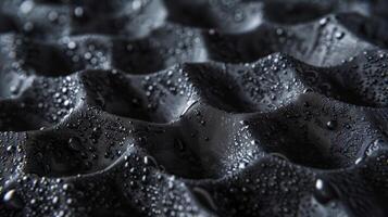 A closeup of rough black foam padding with a texture resembling pebbles blemished with small tears and scs photo