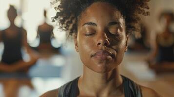 An individual in a meditation class focusing on their breath and practicing mindful awareness of their surroundings photo