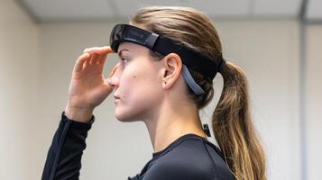 A person using a brainsensing headband to track their cognitive activity while completing various technologybased training exercises photo