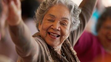 A closeup of an older womans face beaming with joy and satisfaction as she dances in a group with her peers photo