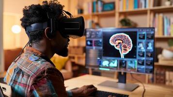 A man sitting at a desk looking at a computer screen and reviewing virtual reality therapy options for his family members brain injury photo