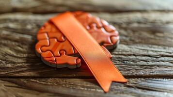 An orange ribbon with a brainshaped puzzle piece to bring attention to the puzzle of brain health and research photo