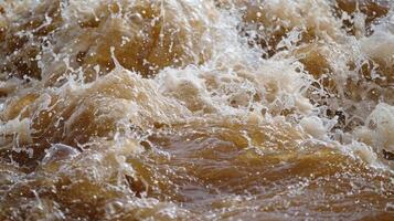 The brown muddy waters of the river are transformed into a frothy churning mass photo