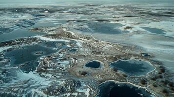 A frozen tundra landscape with small patches of melt ponds creating a surreal and otherworldly scenery photo