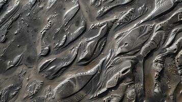 A closeup of the unwavering grit of this sandy shore with rough ridges and patterns left behind by the ebb and flow of the tide photo