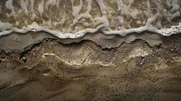 The shoreline is lined with a strip of rough and gritty sand coated with a thin layer of dampness from the crashing waves photo