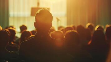 Faint silhouettes of a speaker and a defocused audience at a wellattended public lecture photo