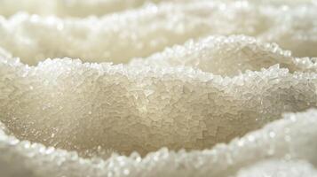 A textured surface of granulated sugar with small bumps and valleys that catch the light and resemble tiny mountains photo