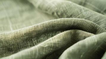 A closeup of a sage green linen tablecloth revealing the soft and supple d of the fabric and its small woven details photo