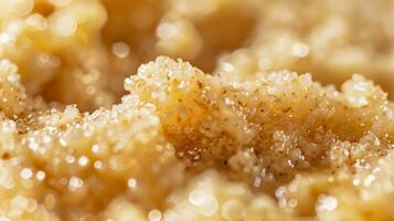 A closeup of cooked oatmeal with a slightly gelatinous texture dotted with specks of brown sugar and small pockets of melted butter photo