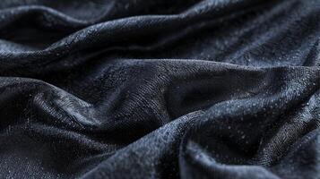 A macro image of obsidian with a dark charcoal color and a velvety smooth texture almost resembling a soft fabric photo