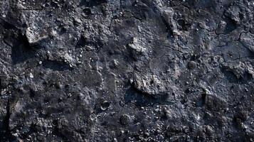 A detailed view of bumpy rough asphalt with small pits and divots resembling the surface of the moon photo