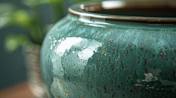 A detailed view of a green glazed pot revealing a glossy almost glasslike finish that reflects light in different angles photo