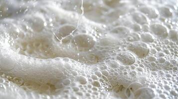 A closeup of a bubbly lather forming on top of a bar of soap showcasing the smooth and slippery texture that makes it perfect for cleansing the skin photo