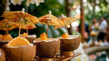 Guests sipping on fruity cocktails served in coconut shells and adorned with umbrellas reminiscent of a beach getaway photo
