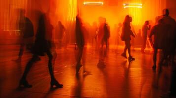 The dimly lit room is transformed by a dreamy blur of orange and yellow with the silhouettes of dancers twirling and raving in the background creating a mesmerizing atmosphere at photo
