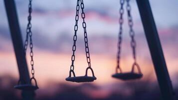 Soft defocused background of swaying swings their outline merging with the twilight sky. photo