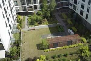 Warsaw, Poland, May 3rd 2024 - Modern residential building and patio with trees. Real estate and housing issues concept. photo