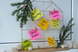 Action board new year's resolutions on colorful sticky notes. Making promises for new year, setting goals. Dream year motivation photo