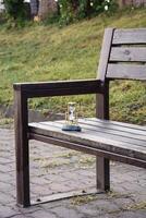 A beautiful hourglass stands on a beautiful bench in the park photo