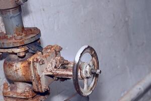 Plumbing. Sewage. Water valve, old rusty faucet in the basement photo