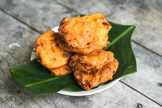 un pila de tofu buñuelos o frito tofu un pan en un hoja lámina. hecho desde un mezcla machacado tofu, un pequeño tapioca harina, verde cebollas, huevos, sal y pimienta. crujiente en el afuera, suave en el dentro foto