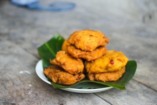 un pila de tofu buñuelos o frito tofu un pan en un hoja lámina. hecho desde un mezcla machacado tofu, un pequeño tapioca harina, verde cebollas, huevos, sal y pimienta. crujiente en el afuera, suave en el dentro foto